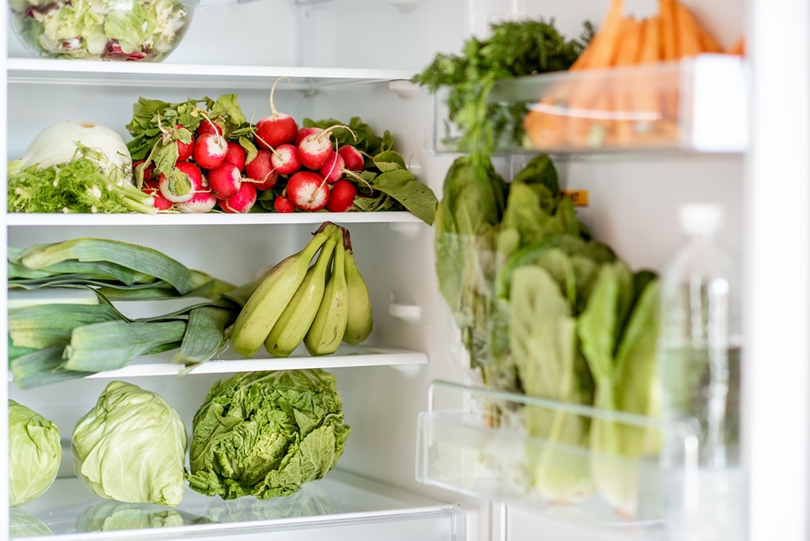 Geladeira doméstica cheia alimentos; frutas, legumes e verduras; geladeira limpa com diversas comidas