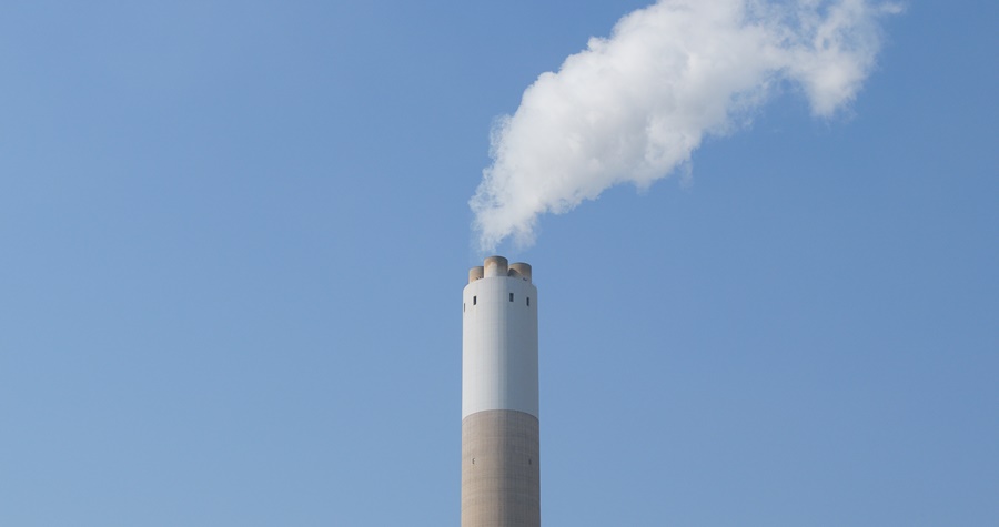 Fumaça da fábrica com emissões de carbono sobre o céu azul