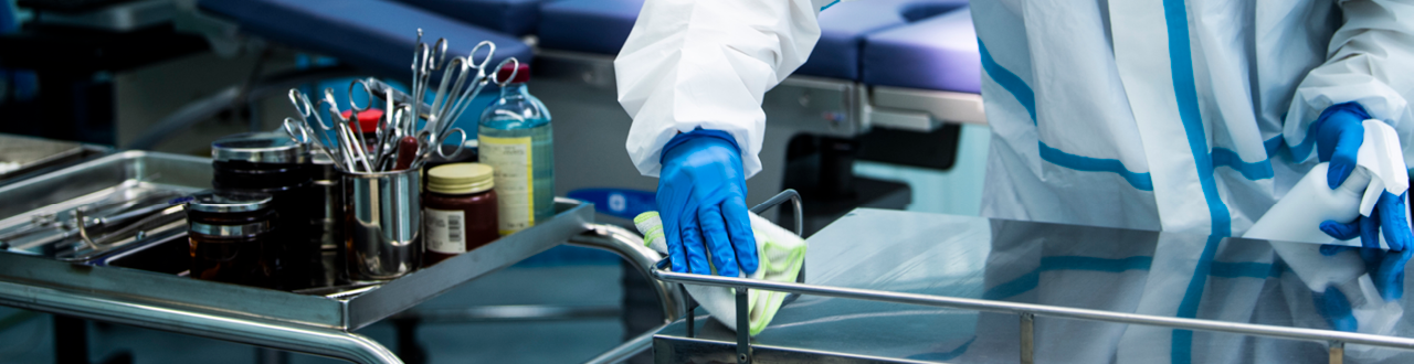 Técnicas de limpeza hospitalar para superfícies menos críticas, mais críticas e artigos críticos, profissional limpando um equipamento com pano de microfibra